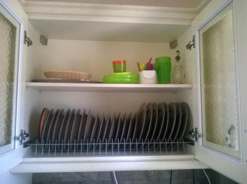 a shelf in a kitchen with bowls and utensils at Nikoloudi Estate in Agios Nikolaos