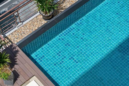 an overhead view of a blue swimming pool with plants at Tisha Hotel ABAC Bangna in Bang Bo