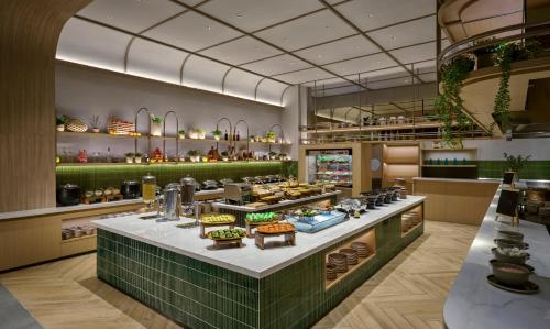 un restaurant avec un comptoir proposant différents types de nourriture dans l'établissement ARTOTEL Living World Kota Wisata, 