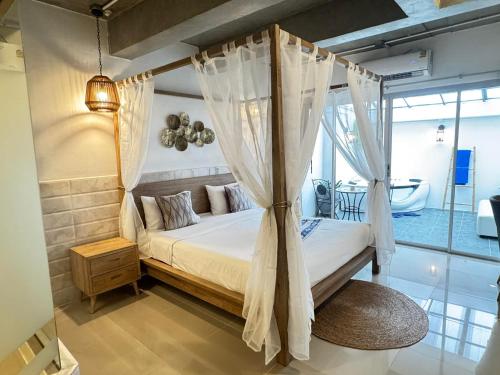 a bedroom with a canopy bed and a tub at The Nest Resort Patong in Patong Beach