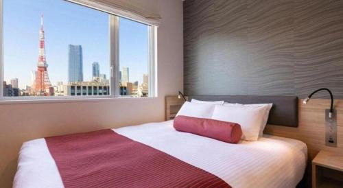 1 dormitorio con 1 cama y vistas a la torre Eiffel en KEIKYU EX INN Hamamatsucho Daimon-Station (Tokyo), en Tokio
