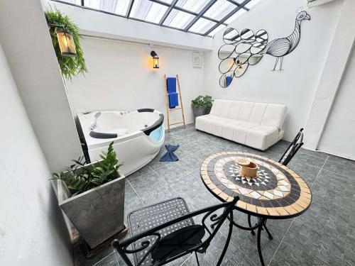 a living room with a tub and a table and a couch at The Nest Resort Patong in Patong Beach