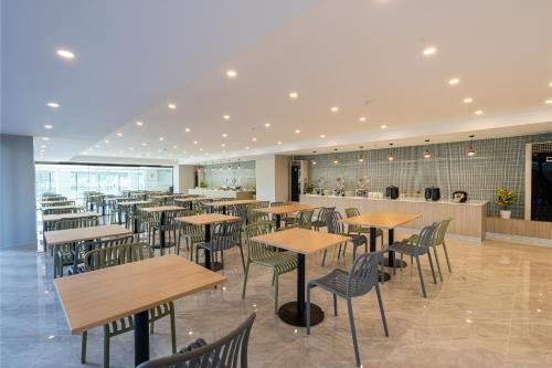 a restaurant with tables and chairs and a bar at Tisha Hotel ABAC Bangna in Bang Bo