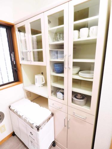 a kitchen with white cabinets and a window at Haku Nest Ichinoe in Tokyo