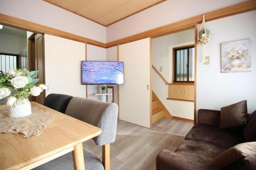a living room with a table and a couch at Haku Nest Ichinoe in Tokyo
