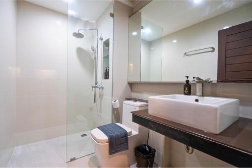 ein Badezimmer mit Waschbecken, Toilette und Dusche in der Unterkunft Tisha Hotel ABAC Bangna in Bang Bo