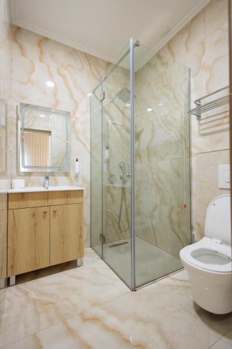 a bathroom with a shower and a toilet and a sink at Ufo Boutique Hotel in Tirana