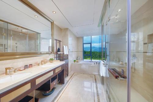 a bathroom with two sinks and a shower at New Century Grand Hotel Zunyi in Zunyi