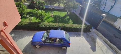 una piccola auto blu parcheggiata in un parcheggio di Great 2BR Retreat for Families and Friends! a Kamëz