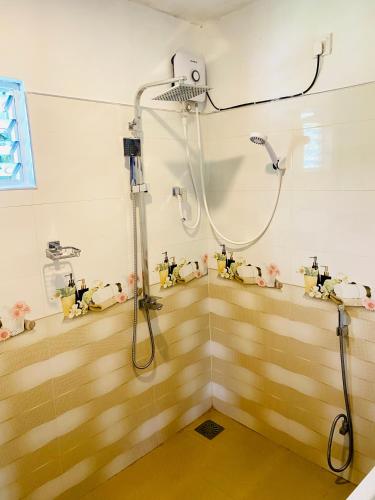 a shower in a bathroom with wooden floors at Hiriketiya Lima Homestay in Dickwella