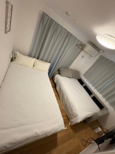 a bedroom with two beds and a window at 吉祥寺千利休302号室 in Musashino