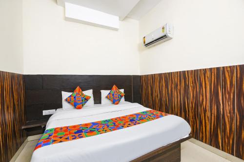 1 dormitorio con 1 cama grande con sábanas coloridas en FabHotel Red Ark Inn, en Lāndrān