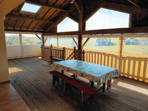 Zimmer mit einem Tisch und einer Bank auf einer Terrasse in der Unterkunft Maison 8 personnes proche Parc in Montournais