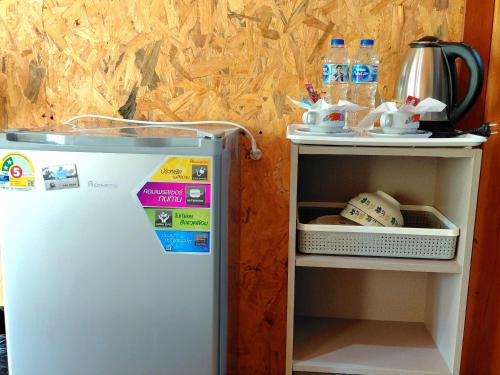 Ein kleiner Kühlschrank neben einem Regal mit einem Baseball in der Unterkunft Nathan Breeze Resort in Ko Muk