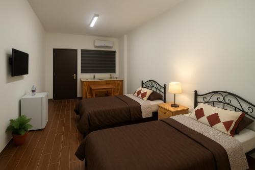 una camera d'albergo con due letti e un lavandino di EMILE ALTWAL Hotel a Madaba