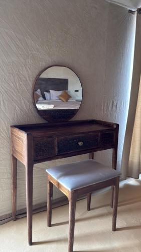 a wooden dressing table with a mirror and a stool at Dream Luxury Majestic Camp in Merzouga