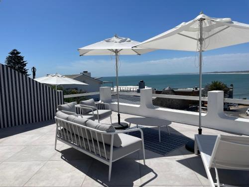a patio with chairs and a table and an umbrella at 16 Mile View in Yzerfontein
