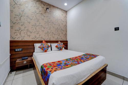a bedroom with a bed with a colorful blanket at FabHotel NRM Residency in Mysore