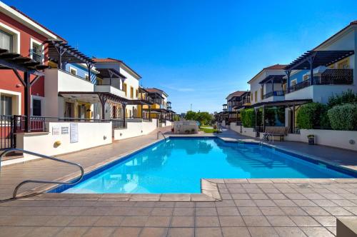 Aphrodite Gardens Apartment by Ezoria Villas في Nea Paphos: حمام سباحة في وسط المبنى