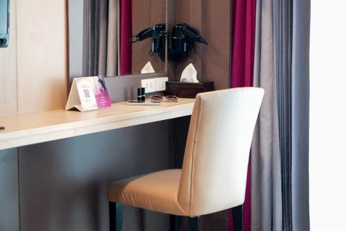 una silla blanca sentada junto a un escritorio con espejo en GLOW Pattaya, en Pattaya South