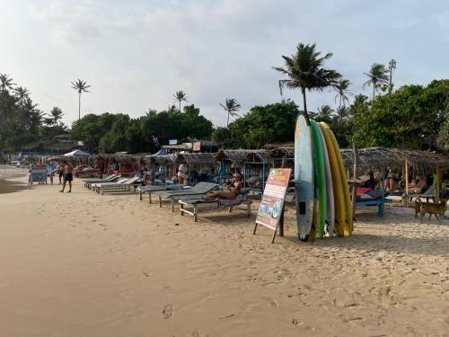 een strand met een hoop surfplanken en een bord bij Haru Ahangama in Ahangama