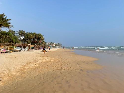 een persoon die op een strand in de buurt van de oceaan loopt bij Haru Ahangama in Ahangama