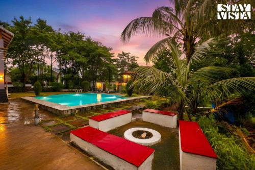 einen Pool in einem Hof mit einem Resort in der Unterkunft Whispers of Green by VEO - Part of StayVista in Trimbak