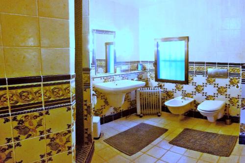 a bathroom with two sinks and a toilet and mirrors at La Cortijera in Benidoleig