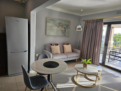 a living room with a table and a couch at Induli on Sage in Plattekloof