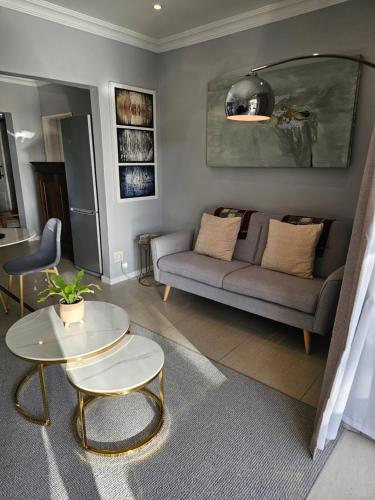 a living room with a couch and a table at Induli on Sage in Plattekloof