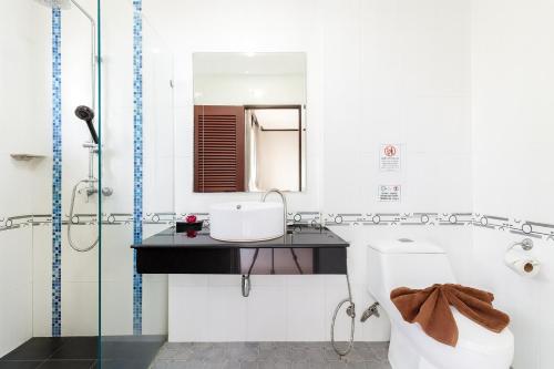 ein Badezimmer mit Waschbecken, Toilette und Spiegel in der Unterkunft The Chic Patong Hotel in Patong Beach