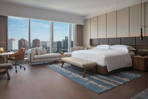 um quarto com uma cama grande e uma janela grande em InterContinental Hotels Zhengzhou em Zhengzhou