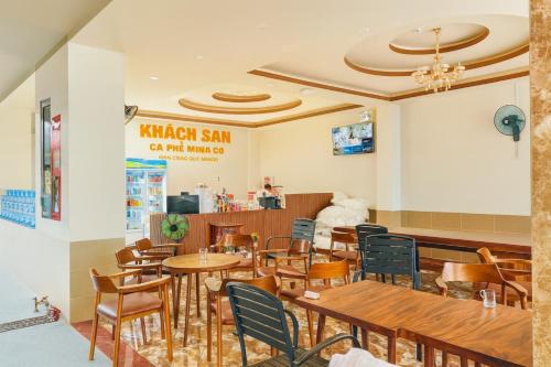 a restaurant with wooden tables and chairs at Khách Sạn - Cà Phê Dinh Cô in Long Hai