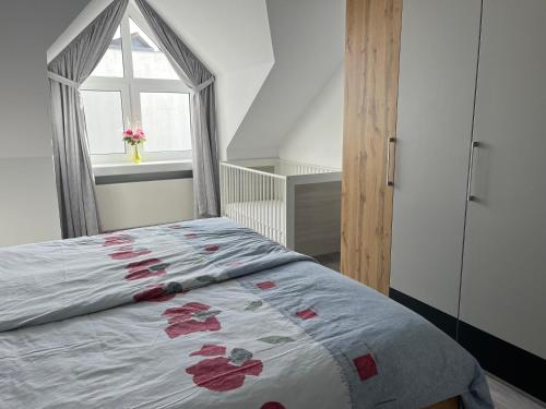 une chambre avec un lit avec des fleurs rouges dessus dans l'établissement Ferienwohnung Sonnenschein, à Bad Pyrmont