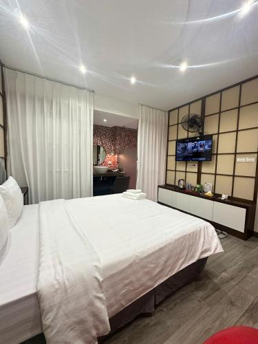 a bedroom with a large white bed and a television at Boutique Hotel in Hanoi