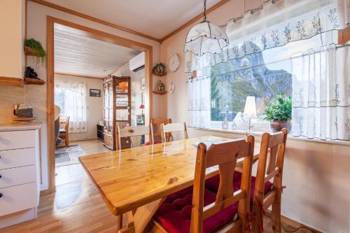 a dining room with a wooden table and a large window at Valen Retro Home, Reine in Reine