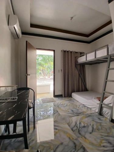 a bedroom with a bunk bed and a desk and a table at correashomestay in Coron