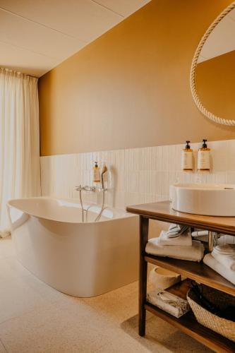 a bathroom with a tub and a sink at Maison LE GOYEN & Spa in Audierne