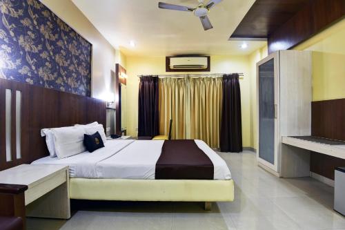una habitación de hotel con una cama y una ventana en Devanshi Inn By Glitz Hotels, en Navi Mumbai