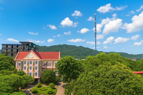 un vieux bâtiment avec un toit rouge et un jardin dans l'établissement Khách Sạn - Cà Phê Dinh Cô, à Long Hải