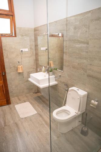 a bathroom with a toilet and a sink at Riverside Lounge Kandy in Sirimalwatta