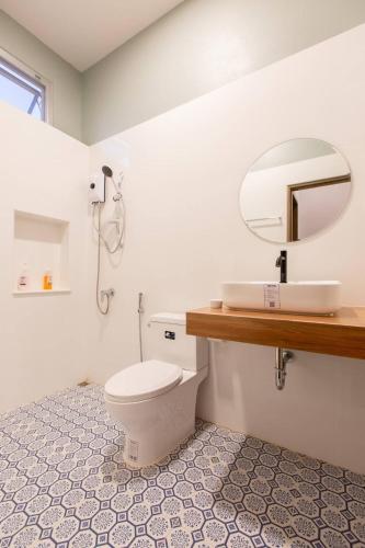 a bathroom with a white toilet and a mirror at Jacuzzi mine hills in Ban Mai