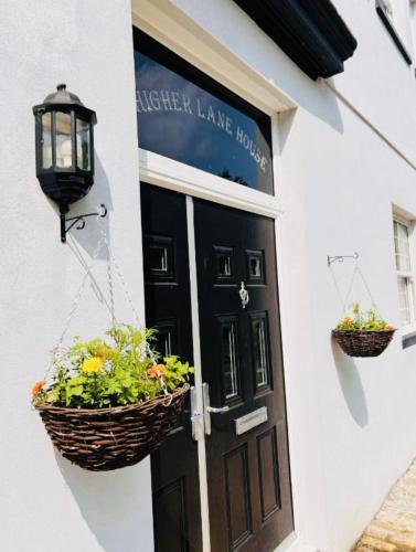 a door of a house with two baskets of flowers at Higher Lane House in Plymouth