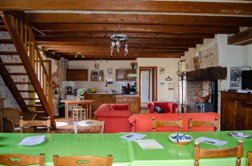 ein Wohnzimmer mit einem grünen Tisch und roten Stühlen in der Unterkunft Maison d'hôtes in Grézels