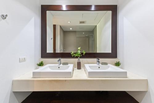 ein Badezimmer mit zwei Waschbecken und einem großen Spiegel in der Unterkunft Bangtao Beach Gardens - Apartment F22 in Ban Lum Fuang