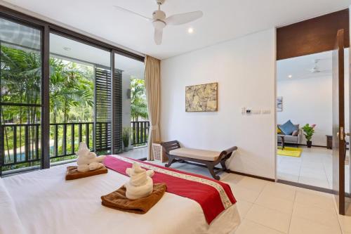 ein Schlafzimmer mit einem Bett und zwei weißen Handtüchern in der Unterkunft Bangtao Beach Gardens - Apartment F22 in Ban Lum Fuang