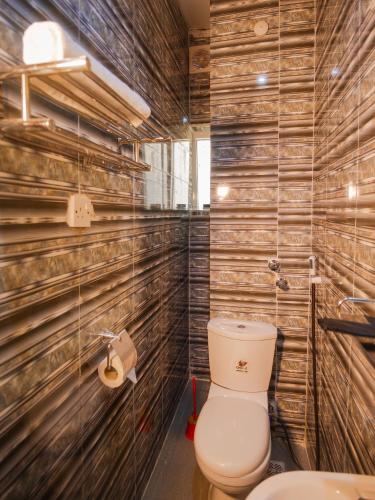 a bathroom with a toilet and a sink at Asato Classic Hotel in Asaba