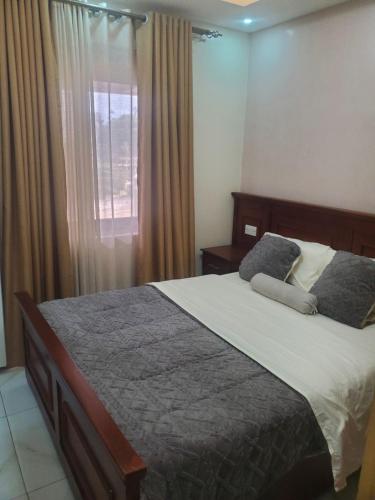 ein Schlafzimmer mit einem Bett und einem Fenster in der Unterkunft Noah's Ark in Kampala