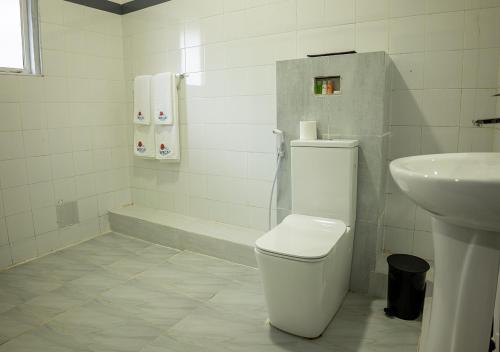 a white bathroom with a toilet and a sink at We Cay Holidays in Nikawatawana