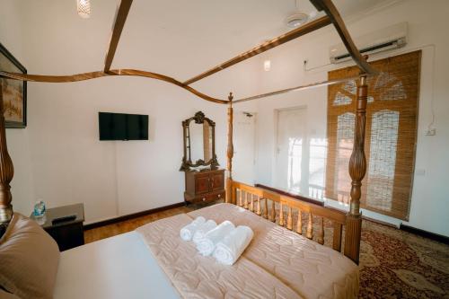 a bedroom with a bed with four pillows on it at SkyPort Villa Negombo in Negombo